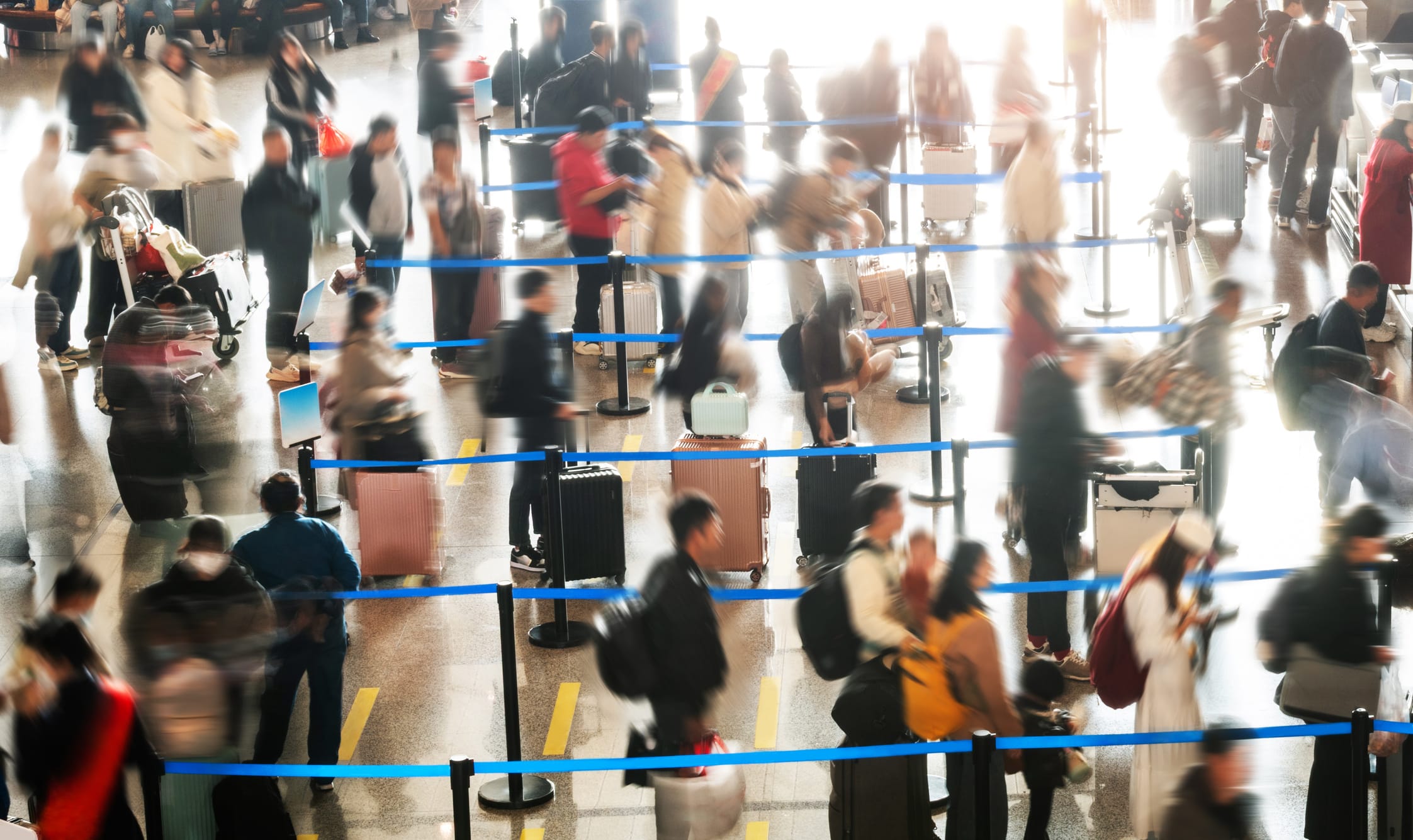 Crowded commuter people with luggage in airport waiting for check-in